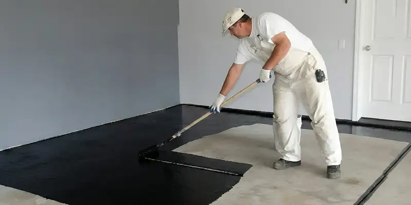 basement waterproofing professional applying waterproof coating to protect a basement floor in Albany, NY